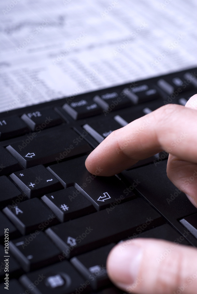 Hand drückt Entertaste auf schwarzem Keyboard. Hand drückt Entertaste auf schwarzem Keyboard.