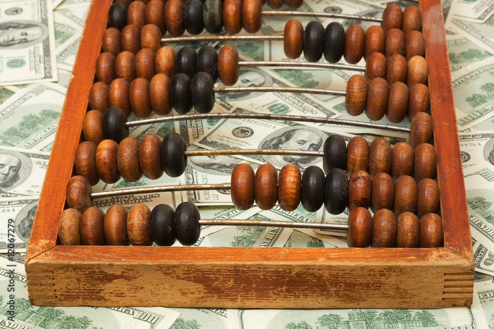 Old abacus on dollars, close-up, shallow depth of field. Old abacus on dollars, close-up, shallow depth of field.