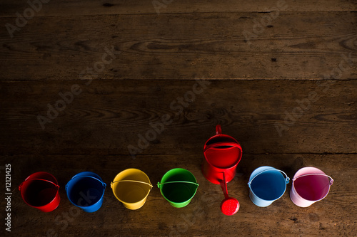 Coloured buckets and watering can in top view photo