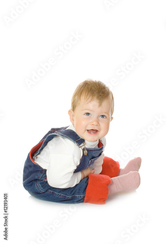 Small smiling baby in blue jeans isolated
