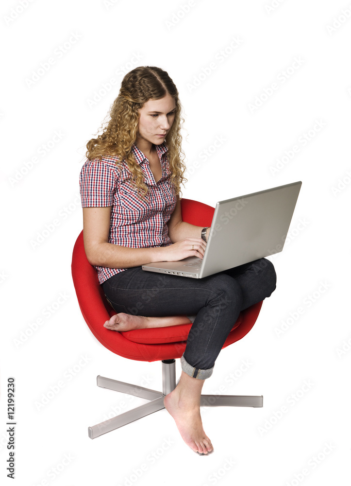 Naklejka premium Girl in a armchair with a computer