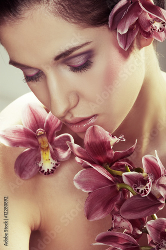 Fototapeta Naklejka Na Ścianę i Meble -  Beautiful young woman with orchid flowers