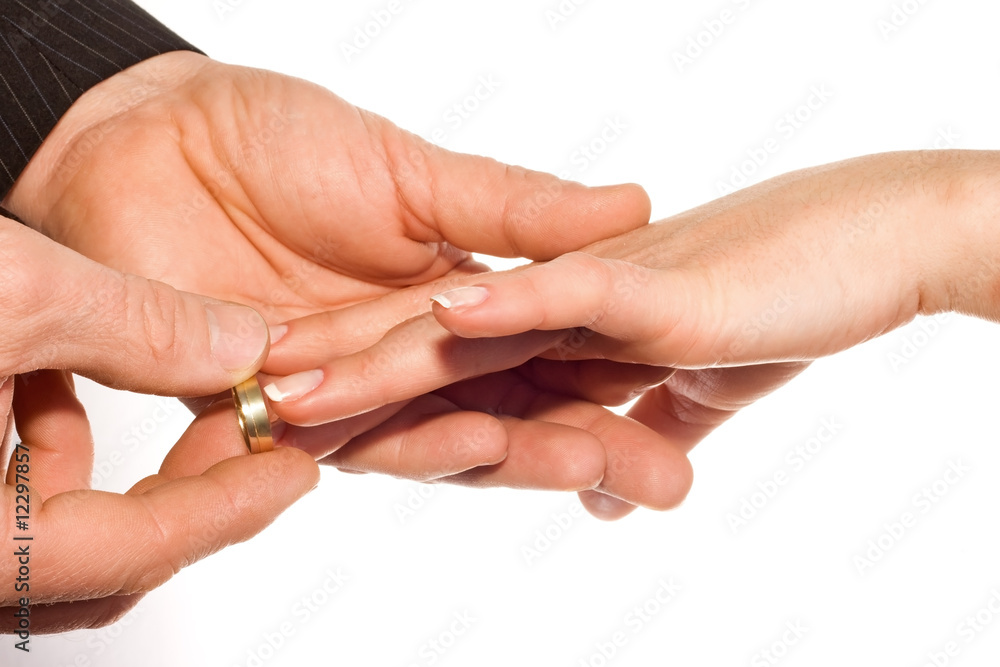 man putting wedding ring on bride's finger man putting wedding ring on bride's finger