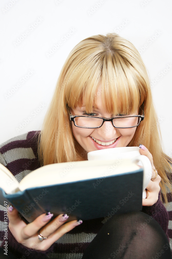 young lady reading a book and saile with cup in hand young lady reading a book and saile with cup in hand