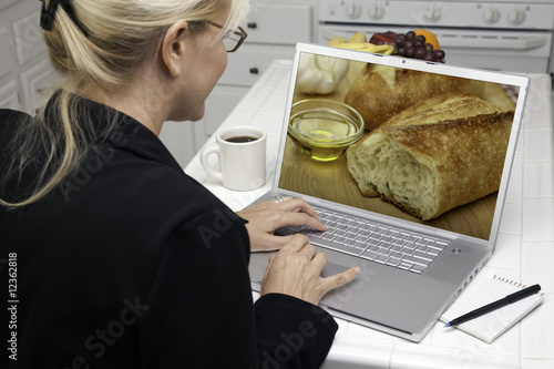 Woman In Kitchen Using Lapt...