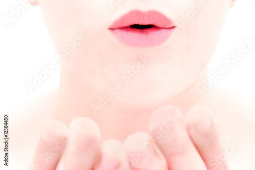 close up of female lips blowing a kiss over white photo
