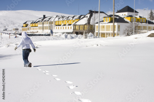 young girl footprint walking away at a snow landscape