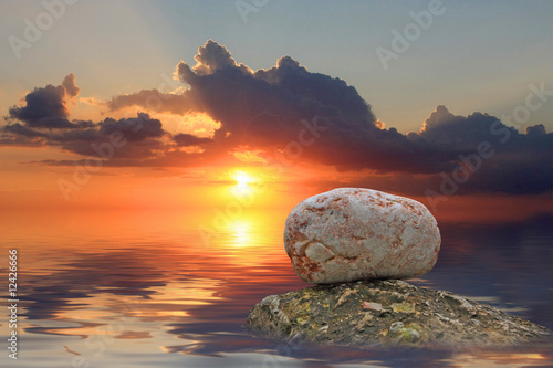 Stones in the water on sunset background photo