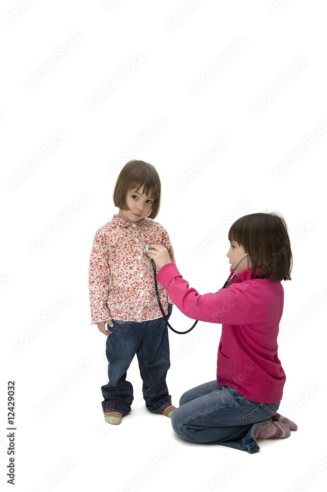 two little girls playing with a stethoscope two little girls playing with a stethoscope