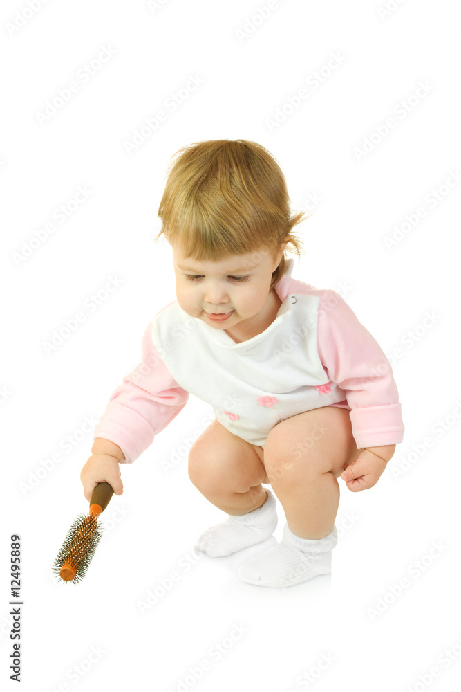 Small baby in pink dress with brush