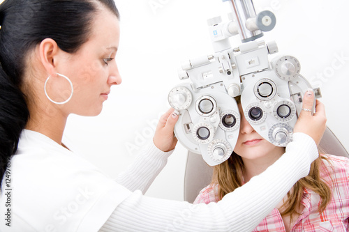 Beautiful young doctor inspect a patient in ophthalmology labor photo