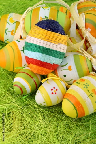 Easten pastel eggs and one linen egg on green background