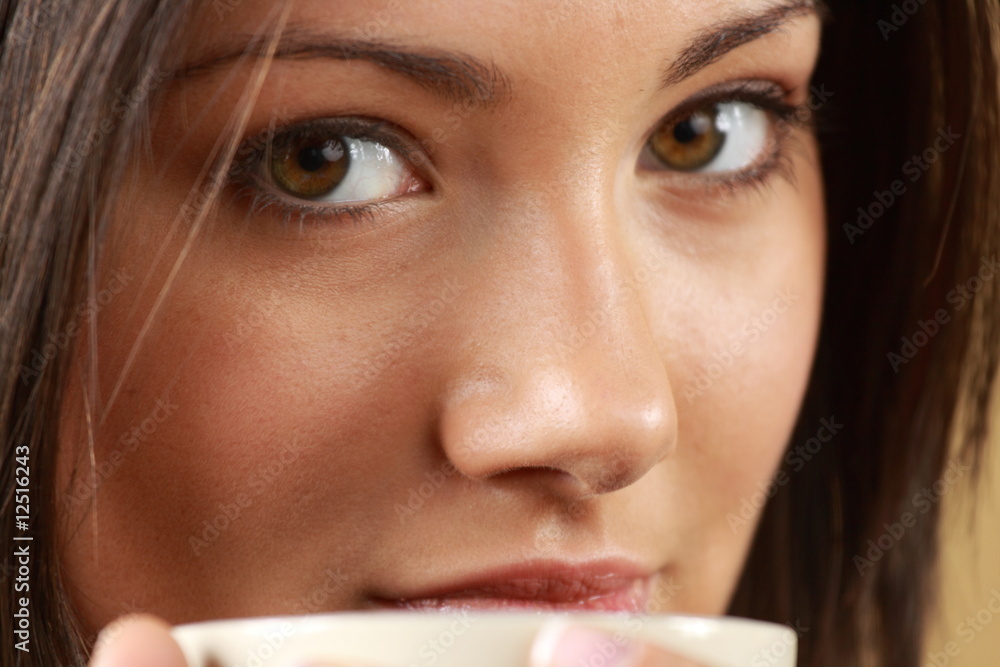 Young woman with beautiful face is having her tea/coffee Young woman with beautiful face is having her tea/coffee