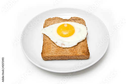 Fried egg on toast isolated on a white studio background.