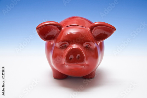 Piggy bank style money box on a blue studio background. photo