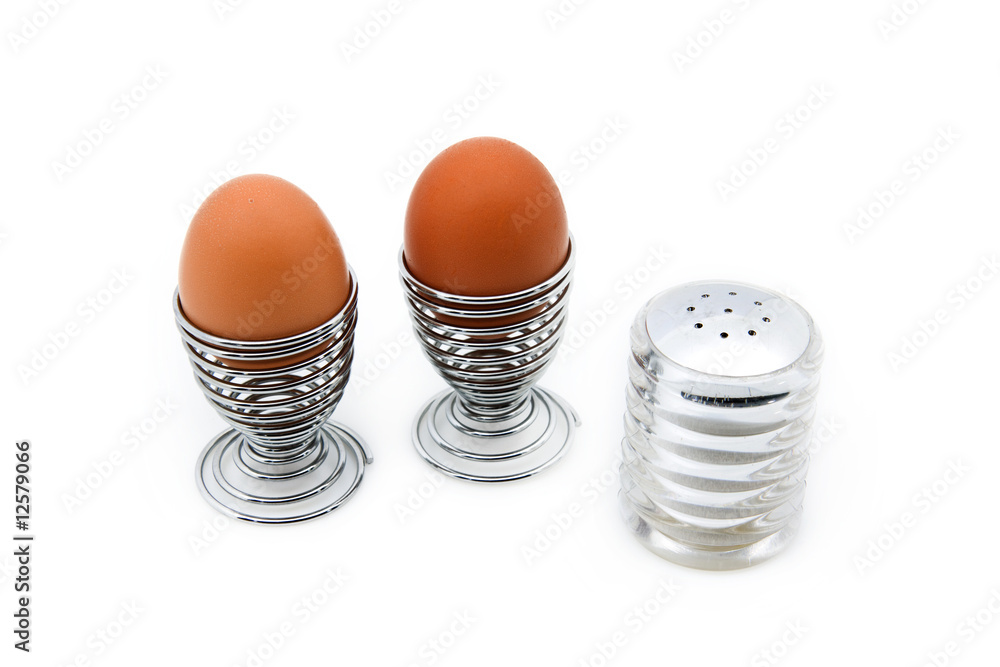 Two eggcups withs eggs next to a salt can Two eggcups withs eggs next to a salt can