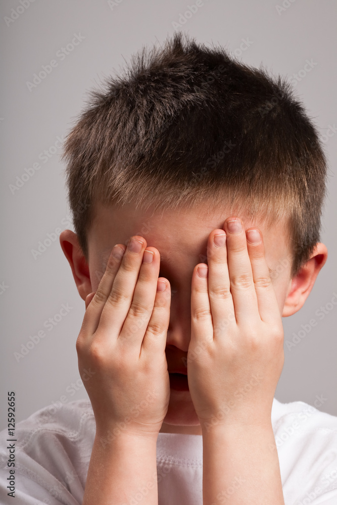 Little boy covering face with hands Little boy covering face with hands