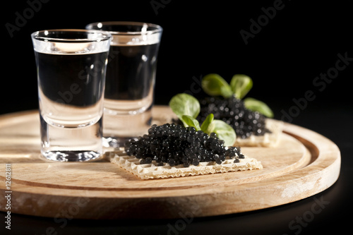 served place setting: vodka and sandwiches with black caviar on photo