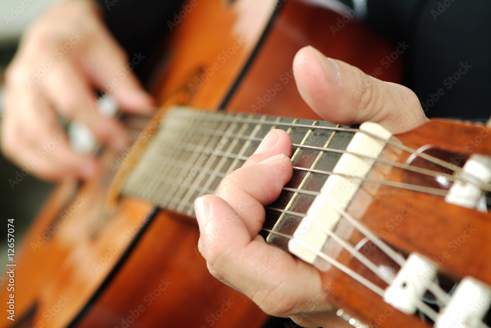 mani che suonano la chitarra classica
