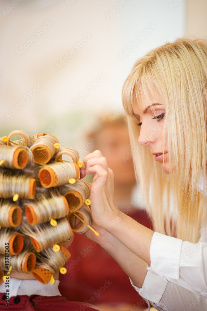 Naklejka premium Female hairdresser working in beauty salon