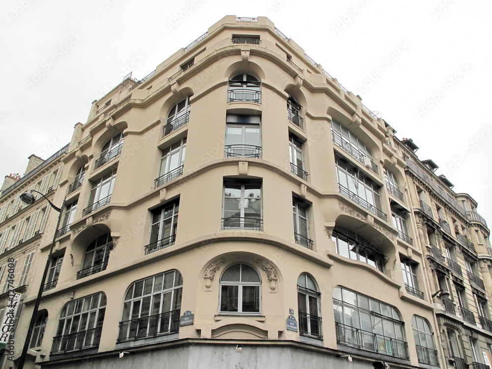 Immeuble en pierre arrondi au coin d'une rue, Paris.