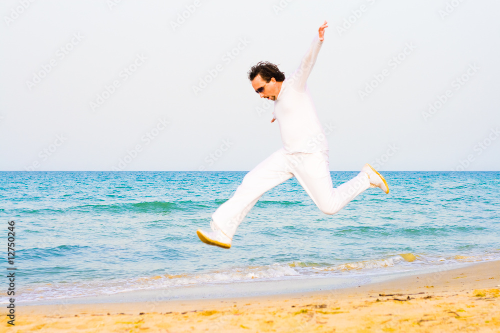 Man in white running on a beach Man in white running on a beach