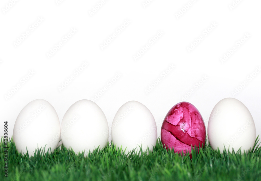Ein rosa Osterei zwischen weissen Eiern