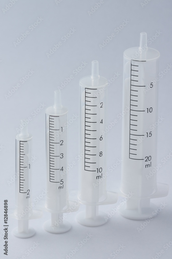 Four empty syringe barrels of increasing sizes Four empty syringe barrels of increasing sizes