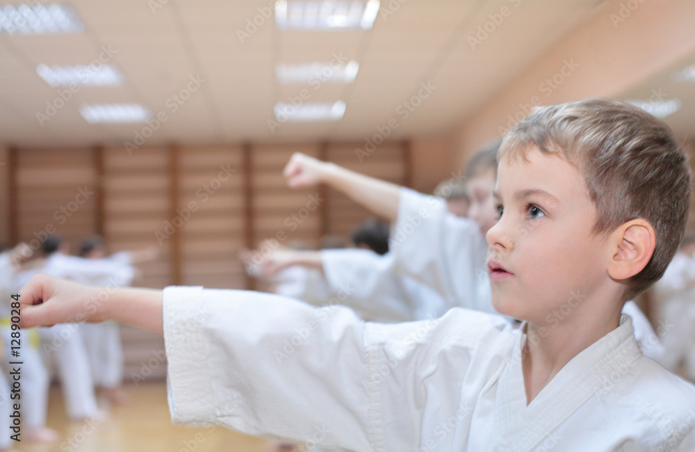 Obraz premium boy in sports hall is engaged in karate