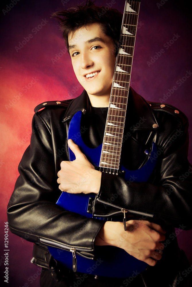 Fototapeta premium handsome young man embracing his guitar