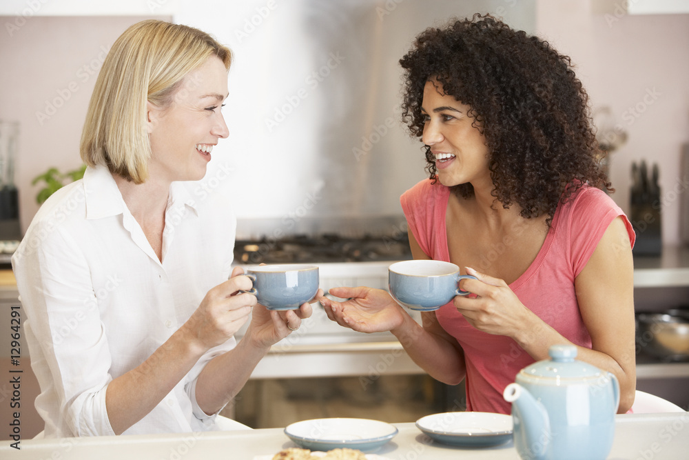 Female Friends Enjoying Tea And Cookies At Home Female Friends Enjoying Tea And Cookies At Home