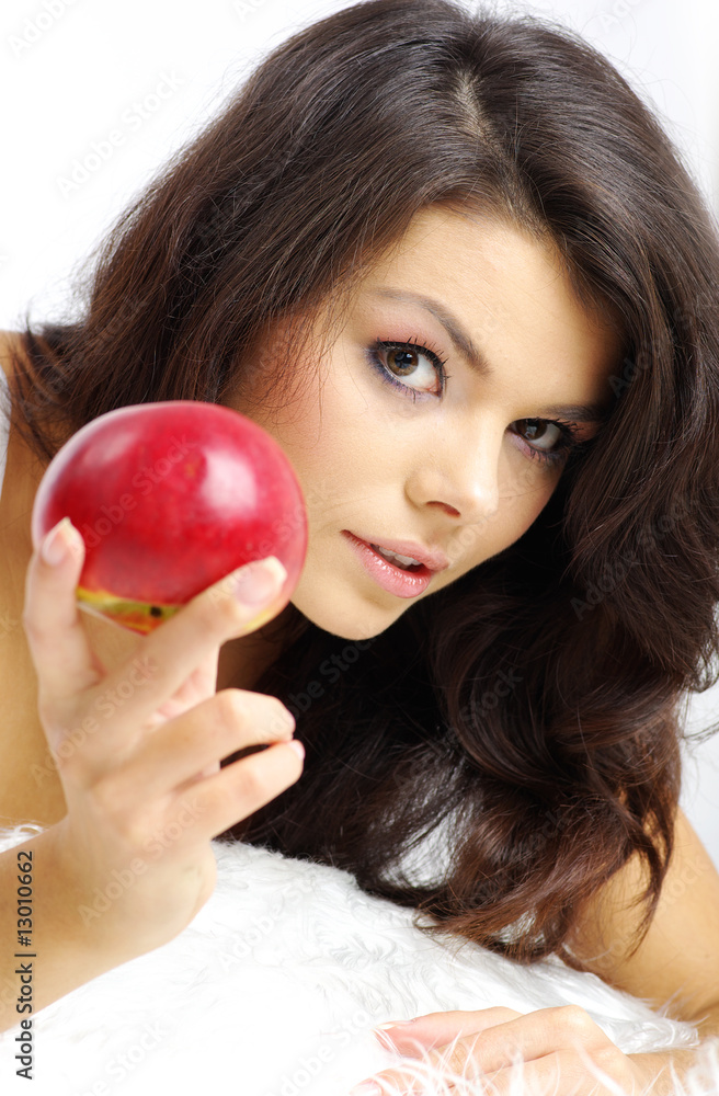 Portrait of woman sitting on bed and eating fresh red apple Portrait of woman sitting on bed and eating fresh red apple