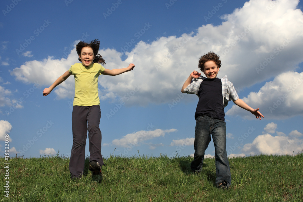 Kids jumping, running against blue sky Kids jumping, running against blue sky