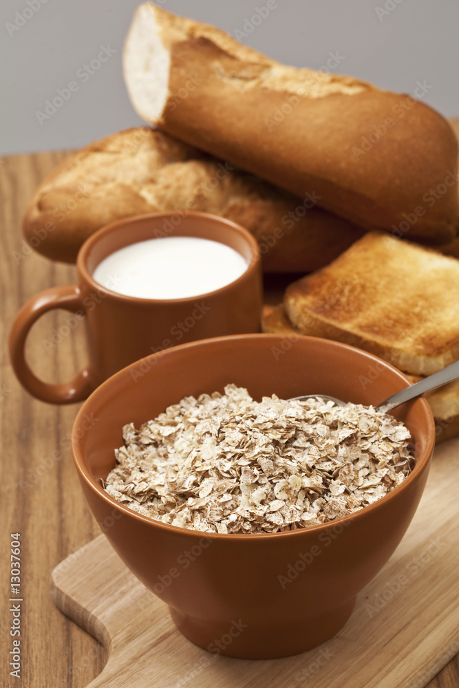 muesli flakes in bowl served with milk and bread close up muesli flakes in bowl served with milk and bread close up