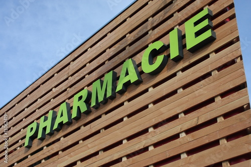 enseigne pharmacie sur un bâtiment commecial en bois