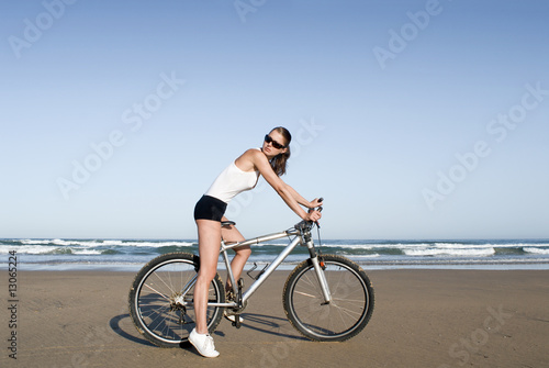 Frau mit Fahrrad am Strand