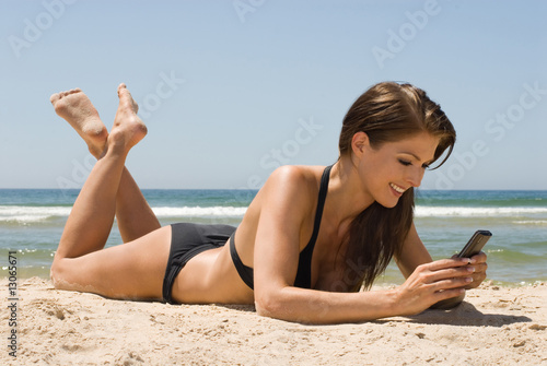 Frau am Strand mit Handy