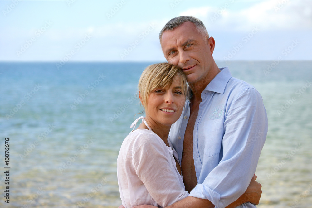 portrait de couple souriant à la mer de face