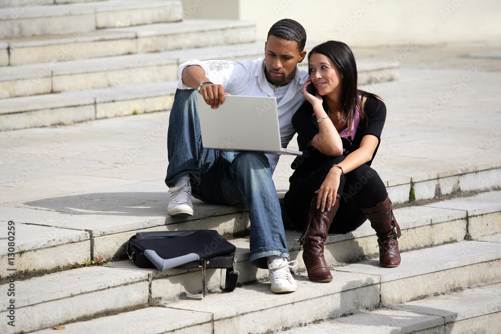 couple assis sur les marches avec ordinateur portable couple assis sur les marches avec ordinateur portable