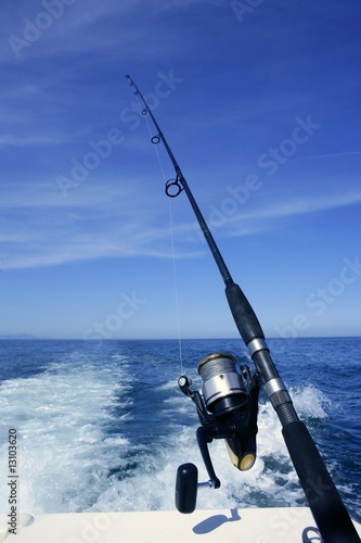 Canvas Print Fishing rod and reel on boat, fishing in blue ocean