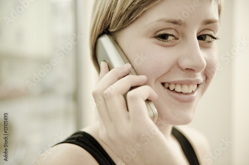 junge frau telefoniert lächelnd und freundlich