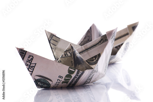 paper boats from dollars banknote on white