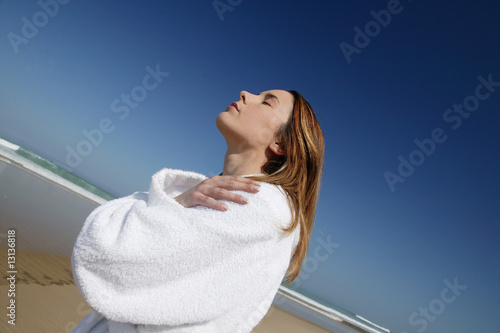 jeune femme en peignoir à la plage