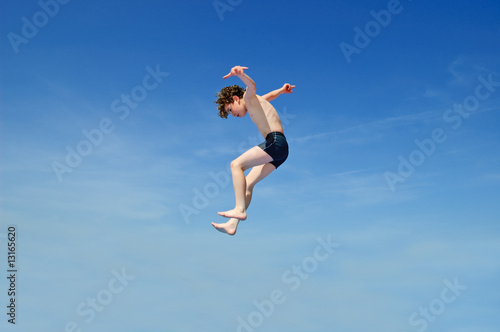 Boy jumping against ble sky