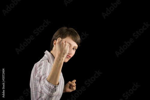 Fist of an aggressive young woman on black background photo