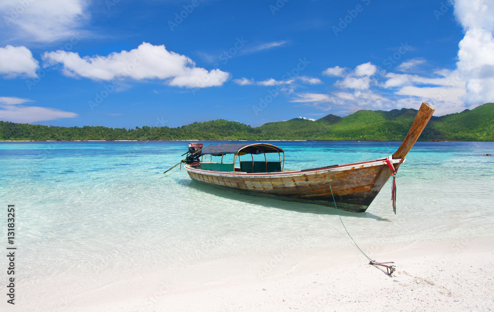 longtail boat in beautiful lagoon near beach with white sand longtail boat in beautiful lagoon near beach with white sand