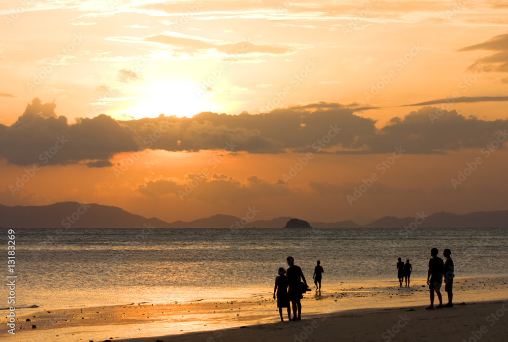 peoples on beach look to sunset