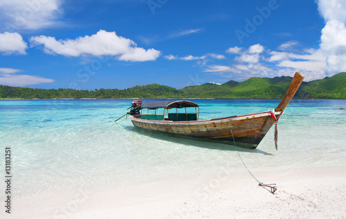 longtail boat in beautiful lagoon near beach with white sand