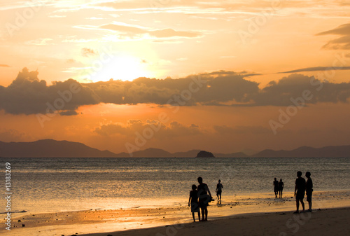 peoples on beach look to sunset
