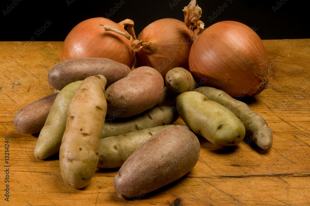 fingerling potatoes and onions on old cutting board fingerling potatoes and onions on old cutting board